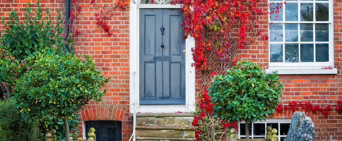 Blue front door to a home of a red-brick house