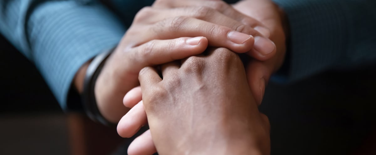 Close-up of two adults holding hands