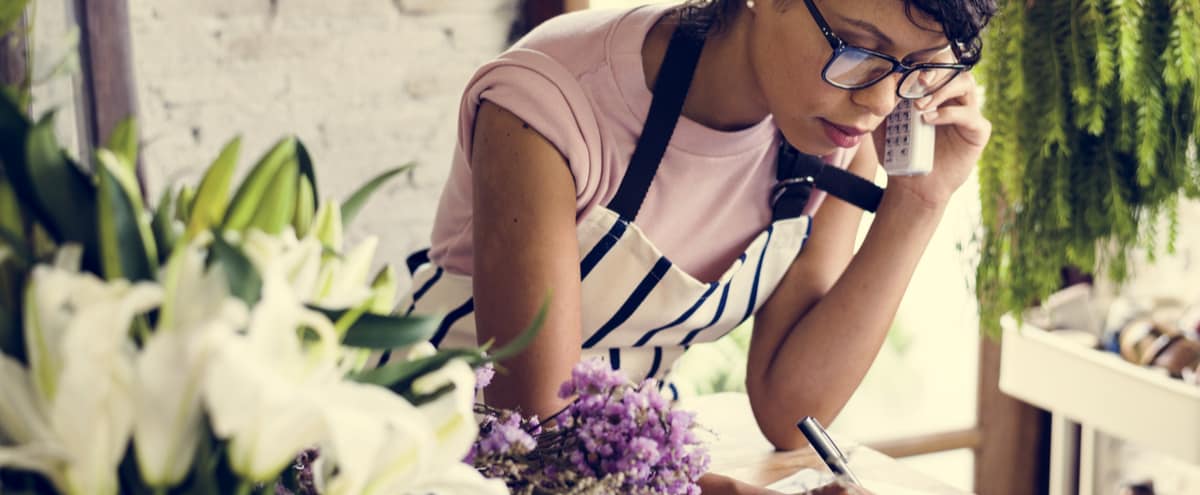 A woman on the phone in a florist.