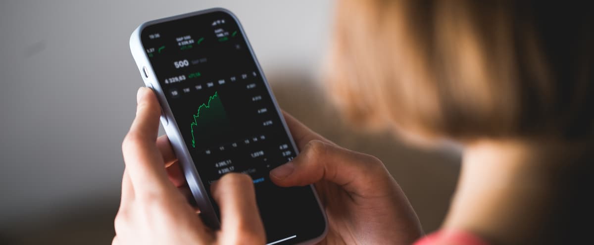 a woman looking at investments on her phone
