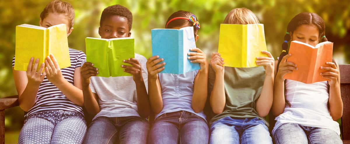 Five children sitting in a line reading books.