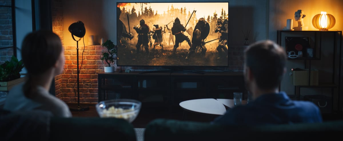 A couple watching a film on a home cinema screen.