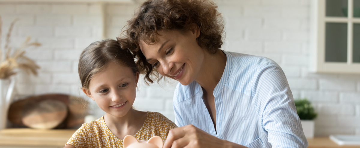 Mother and daughter saving in a piggy bank