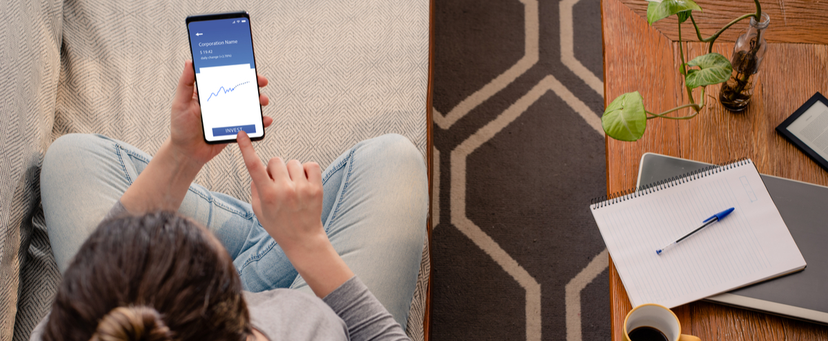 A woman looking at investments on her phone.