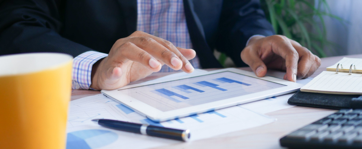 Business man looking at charts on a tablet.