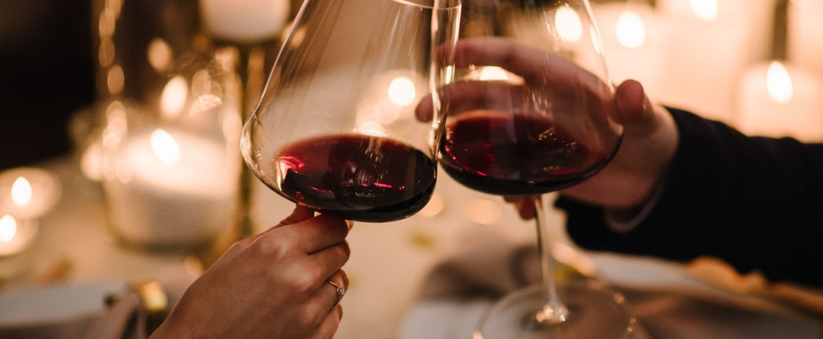 A couple toasting with a glass of wine.