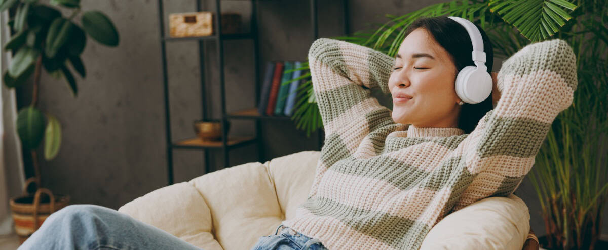A woman relaxing with headphones on.
