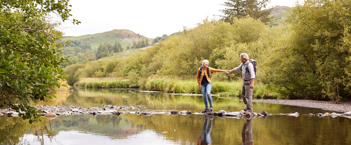 A couple walking across stepping stones.