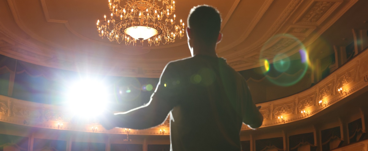 An actor rehearsing on a theatre stage.