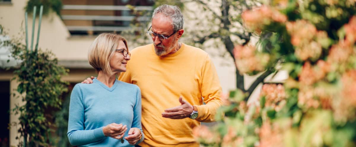 Mature couple walking outside a house