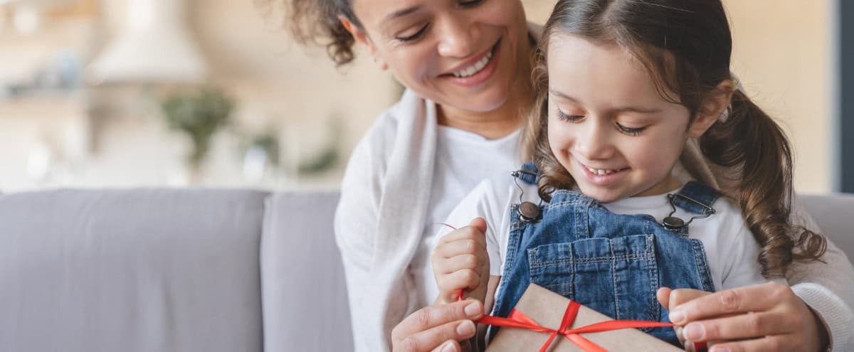 A mother and daughter unwrapping a gift.