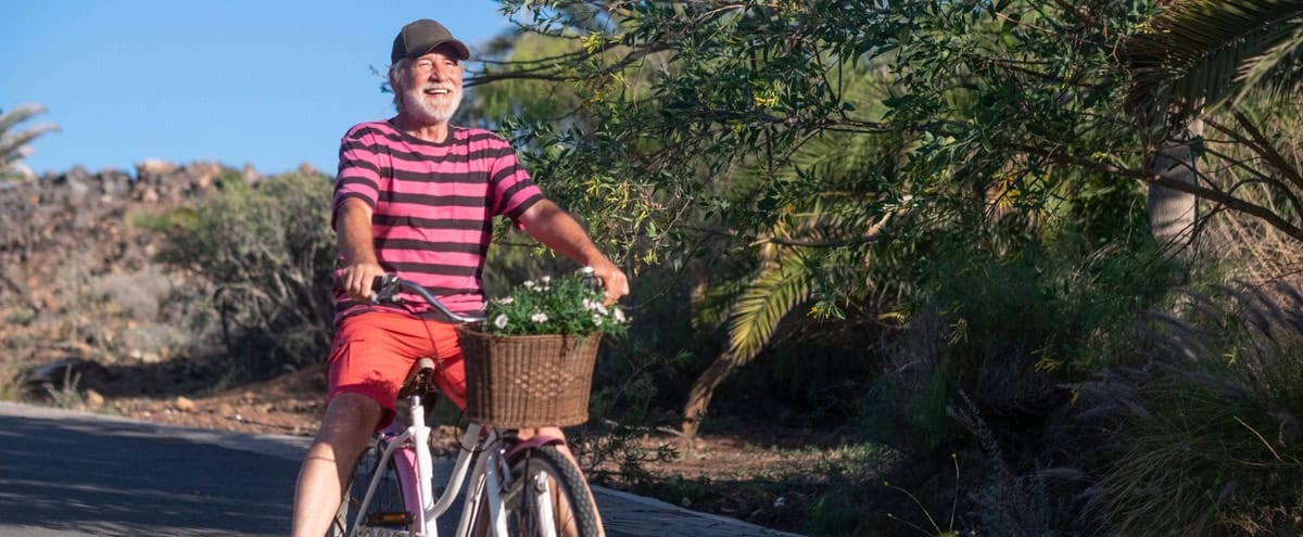 Happy senior man riding a bicycle.