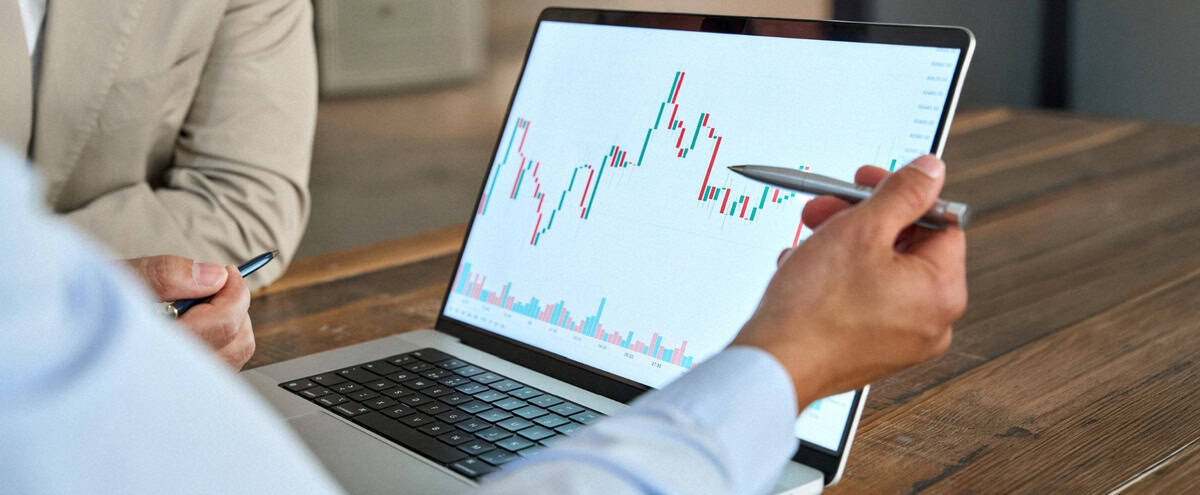 A man reviewing stock market movements on a laptop.
